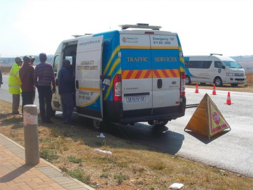 Officials and motorists standing outside the Mogale City Traffic Department Vehicle.