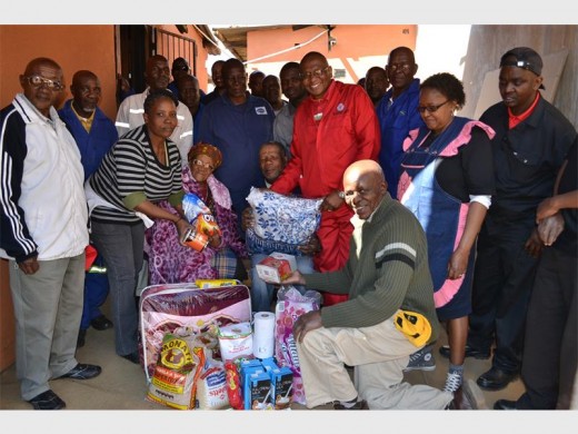 Members of the Methodist Church of Southern Africa handing over groceries and blankets to Mary Maluleka and her son Alfred (seated). Photo: Sipho None.