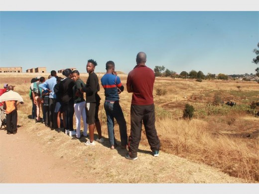Curious residents gather to get a glimpse of the body in the ditch.