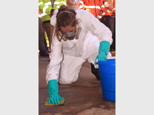 Shalene Botha, crime scene clean-up crew member cleaning a staged crime scene at a demonstration.