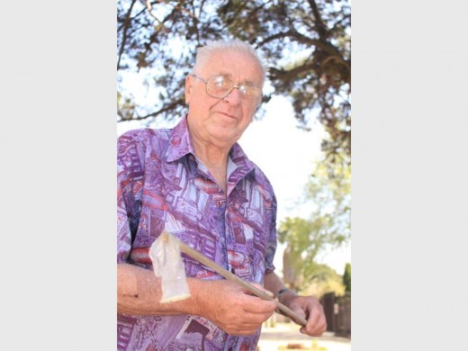 Sepp Dubs, resident of Burger Street, disposing of one of the many condoms lying outside his home.