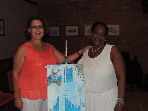 Rene Avis handing over a beautiful painting to its proud owner.