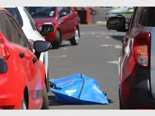 The body of the victim who was shot in Rissik Street this afternoon was put into a blue body bag by Krugersdorp Police soon after they arrived on scene.