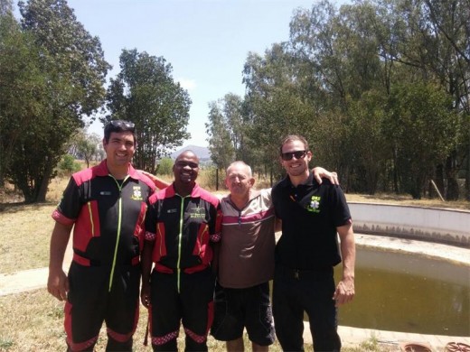 Wian de Beer, Sphe Dlamini and Bradley Smith pose with one of Logwood Villiages' residents after a quick floor hockey match against their finest players. Photo: Braden Stephenson