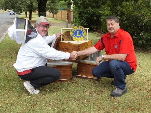 Johann Marx, beekeeper shakes hands with Ivan du Plooy, president of the Krugersdorp Lions Club in front of sponsored bee hives. Photo: Supplied