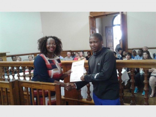 Sports, Arts, Culture and Recreation Manager at Mogale City, Zingisa Jemsana handing a certificate to Abrahim Malenga.
