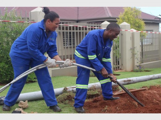 Christel Jack and Dumisani Magatyana, employees of Mogale City Municipality infrastructure department pull cables out of the hole to install the new electricity pole after the damaged one was removed.