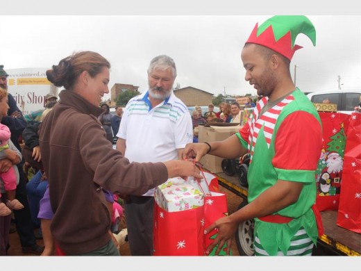 Kersvader se elfie het gehelp om die yslike groot geskenkpakkies aan inwoners oor te handig.