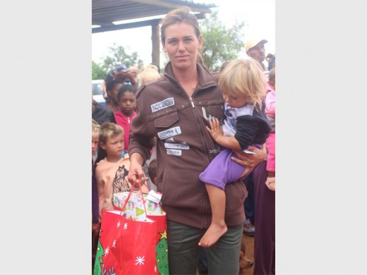 Sonette Engelbrecht hou 'n yslike groot geskenkpak in haar hand terwyl Nakita Pitzer nuuskierig loer wat in die sak is.