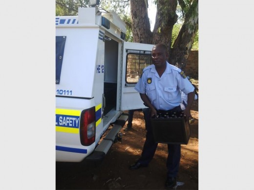A member of the police confiscates the illegal liquor. Photo: Submitted.