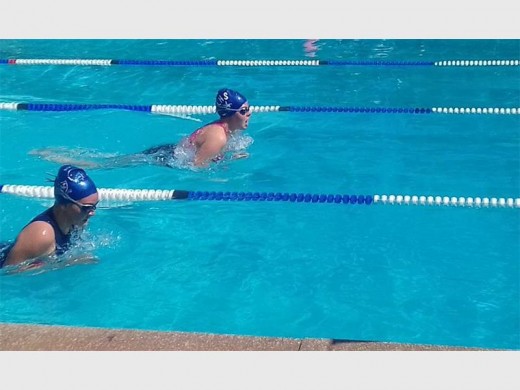 Two junior swimmers battling for first place.