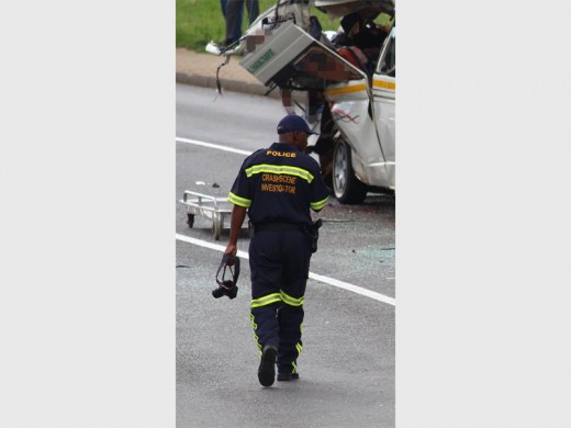 A Crime Scene Investigator walks towards the body of a deceased victim after the horrific collision on the R24, next to the premises of the Krugersdorp Correctional Services.