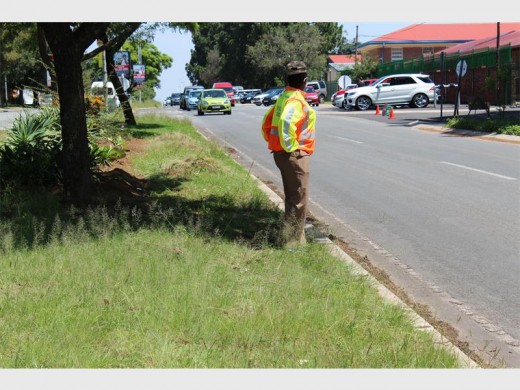 An officer standing near one of KHS's entrances making sure motorists do not disregard the rules of the road.