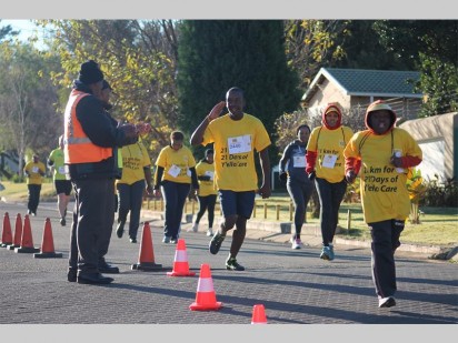 "I've made it sir": A runner salutes a security guard near the finish of the 10km during Saturday's MTN SA Foundation Marathon.