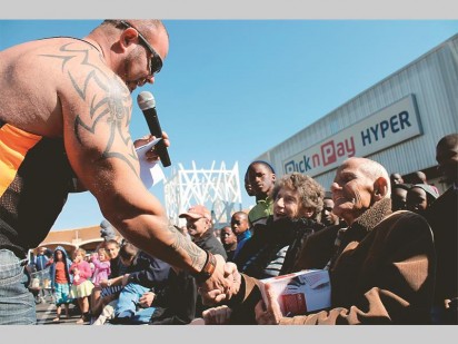 Owner and SAPW Heavyeight title holder, Gerhard Kuyper hands over a gift to the oldest dad in the crowd, Johan le Roux (84).