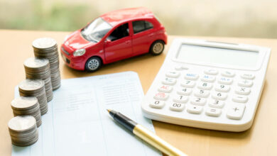 Coins stack in columns on saving book and car on finance concept