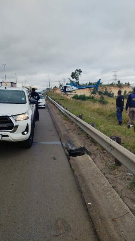 Two arrested as police helicopter and law enforcement flood scene following reported robbery incident.