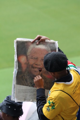 SHOCKING OR SWEET: A man rubs a sucker on the lips of a Nelson Mandela poster on Tuesday before licking it.