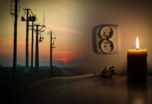 Blackout, candle with a socket, power cut - no electricity, the flame of a candle, circuit breaker, electrical outlet plug