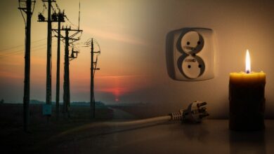 Blackout, candle with a socket, power cut - no electricity, the flame of a candle, circuit breaker, electrical outlet plug