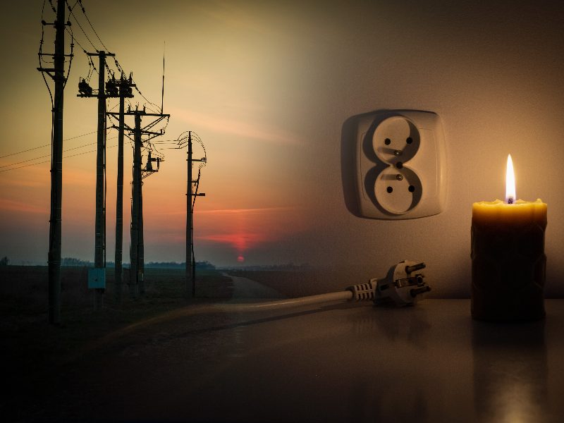 Blackout, candle with a socket, power cut - no electricity, the flame of a candle, circuit breaker, electrical outlet plug