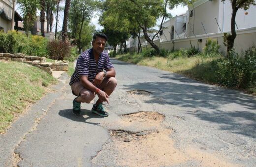 Ward councillor Vino Reddy showing the Fourways Review the potholes on Dennis Road.
