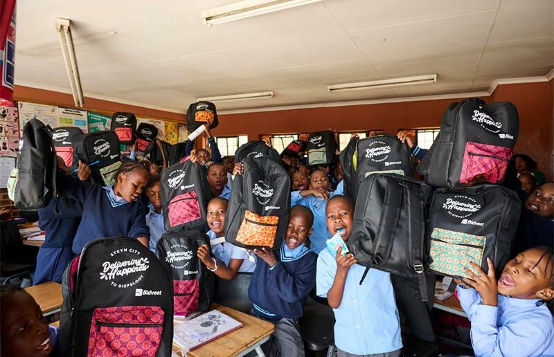 Reshomile Primary School learners showcasing their new backpacks received during the annual Delivering Happiness to Diepsloot initiative by Steyn City Foundation on October 28. Photo: Supplied