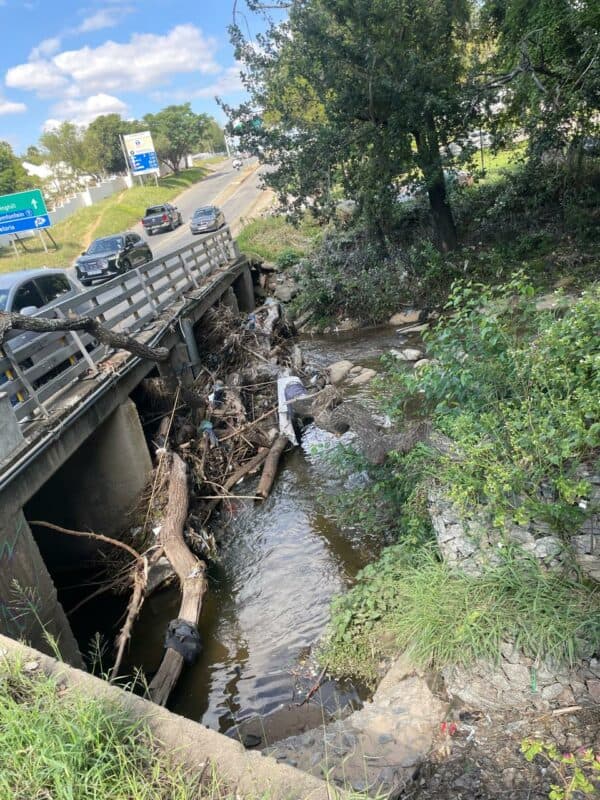 Residents are raising alarm over debris and litter piling up at a bridge in Paulshof Spruit Park, worsening pollution along the riverbanks.