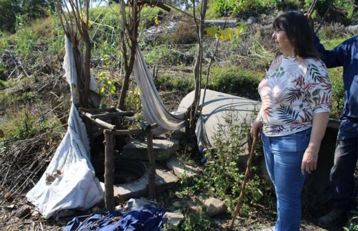 June Julyan, from Paulshof Residents and Ratepayers Association, by the open sewage drain used as a toilet facility at the informal settlement at the confluence of the Braamfontein and Sandspruit rivers on June 2, 2026. Photo: Ayanda Ntshingila