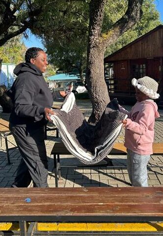 Xolelani Ngwenya and her daughter Penelope Ngwenya receive a blanket to keep warm on June 08, 2026 . Photo: Cleopatra Fothane.
