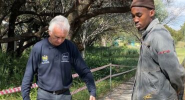 Ward 94 councillor David Foley and Brian Masemola measure a pedestrian walkway to assess whether it could be adapted for vehicle access on June 18, 2026. Photo: Ditiro Masuku