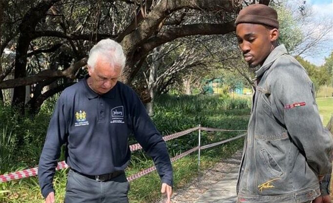 Ward 94 councillor David Foley and Brian Masemola measure a pedestrian walkway to assess whether it could be adapted for vehicle access on June 18, 2026. Photo: Ditiro Masuku