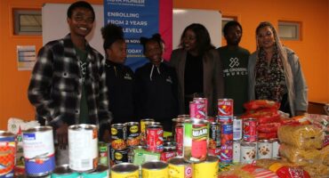 Crossing Cares staff, along with Nova Pioneer learners and the Dean of Students, are showing the food parcels the parents helped gather for the food drive on July 10, 2026. Photo: Reitumetse Gugushe
