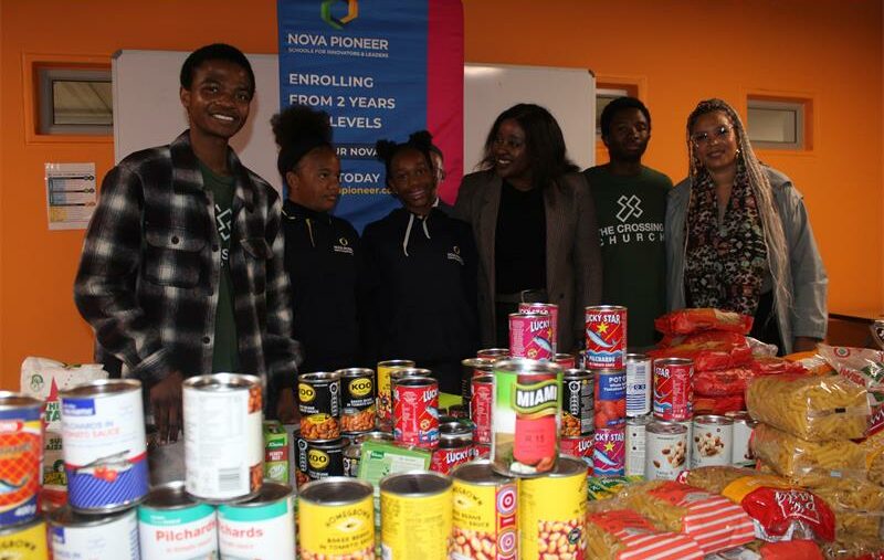 Crossing Cares staff, along with Nova Pioneer learners and the Dean of Students, are showing the food parcels the parents helped gather for the food drive on July 10, 2026. Photo: Reitumetse Gugushe