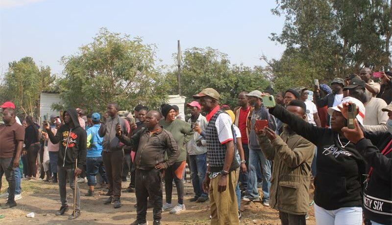 Community members with their phones out, capturing the moment when the church was being demolished on July 23, 2026. Photo: Reitumetse Gugushe