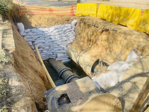 A deep trench contains the sewer rising main, with sandbags, safety barriers, and ongoing construction work as part of the Craigavon sewer replacement project on July 30, 2026. Photo: Ayanda Ntshingila.