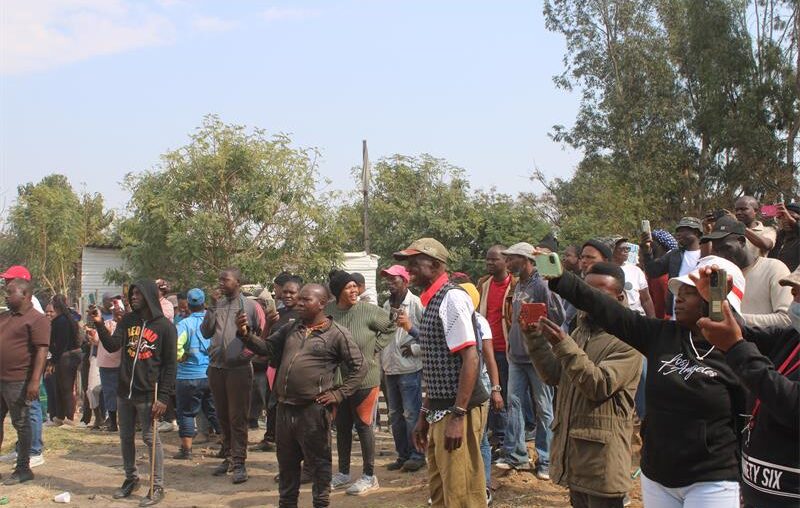 Community members with their phones out, capturing the moment when the church was being demolished on July 23, 2026. Photo: Reitumetse Gugushe