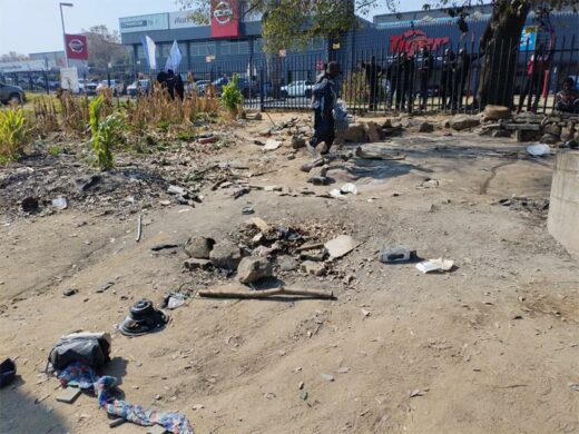 Workers clear debris, scrap metal, and other materials from the site following the removal of an illegal occupation. Photo: Supplied