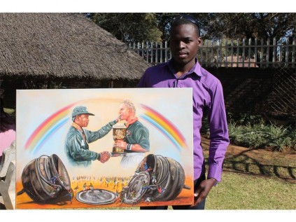 Keith Zenda holds up one of his paintings.
