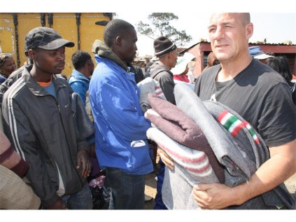 A member of New Beginnings Care Centre is seen distributing blankets to the Angelo victims of the blaze.