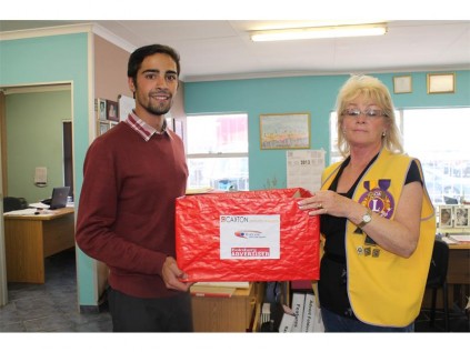 Ricardo de Souza (the Advertiser) hands over the collected spectacles to Nora Norris (Boksburg Lions Club).