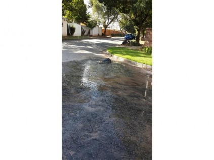 ’n Waterpyp wat in Pitout Weg, Witfield, gebreek het, se gat is met swart sakke gevul.