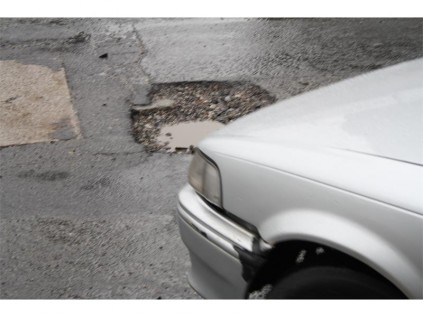 The potholes damage vehicles and lead to traffic congestion as motorists were seen negotiating their way around these potholes.