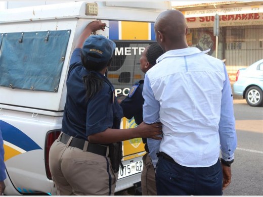 One of the 81 undocumented persons arrested is taken into the Metro Police van.