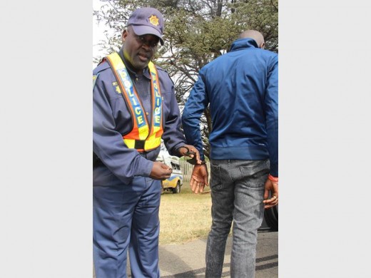 W/O Lucky Raboshaba is seen handcuffing the Nigerian national, who was found in possession of drugs during the traffic stop along Jubilee Road, Boksburg South.