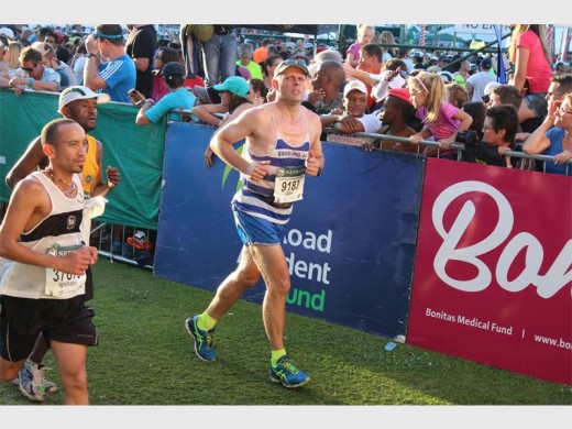 Gary Corin arrives at Sahara Kingsmead Stadium in Durban in a finishing time of 10:35:52 to earn a bronze medal. Photographer: Logan Green.