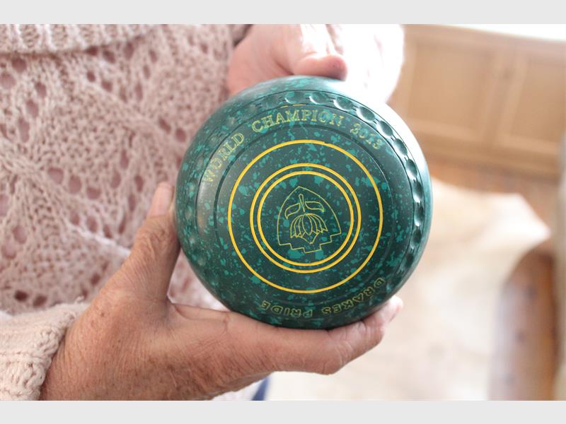 Green bowls ball held in a woman's hand