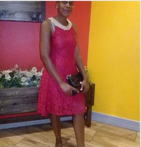 Woman in a red dress posing for a photo.