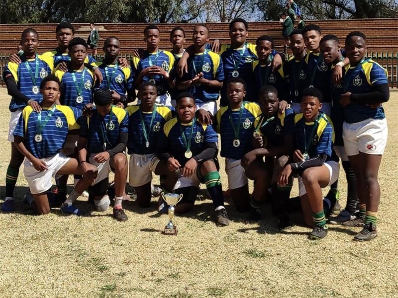 Young rugby team celebrating victory with medals and trophy, showing team spirit and sports achievement.