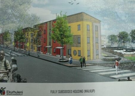 Yellow and red walk-up flats, with people walking outside the buildings